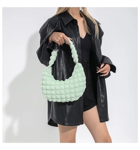 Detail of light green ruched bubble texture fabric on a stylish crescent shoulder bag