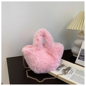 Détail d'un sac seau en peluche rose avec fourrure synthétique et chaîne en métal doré
