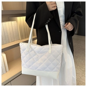 Dettaglio della borsa tote trapuntata bianca con motivo a rombi e manici in ecopelle