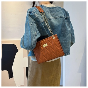 Brown quilted PU leather shoulder bag with gold chain strap shown from a side view