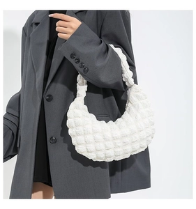 Detail of white quilted bubble texture on a crescent shoulder bag with soft 3D pleated surface