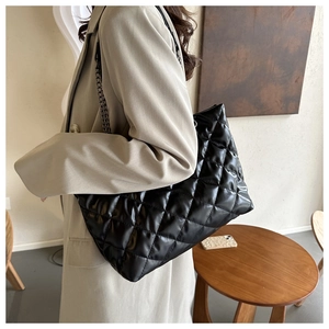 Détail du grand sac cabas noir en similicuir matelassé avec une bandoulière chaîne épaisse