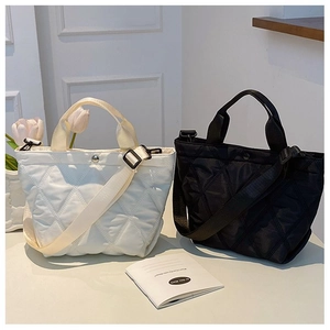 Gros plan de sacs cabas matelassés noir et blanc avec larges bandoulières en nylon