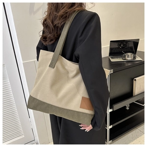 Dettaglio di una grande borsa tote in tela beige e verde oliva in un ufficio