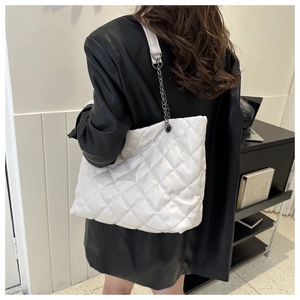 Vue détaillée d'un sac bandoulière matelassé blanc avec chaîne argentée sur modèle