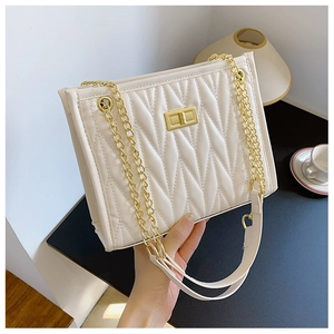 Detail of quilted creamy white crossbody bag with gold chain and metal twist lock