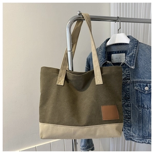 Dettaglio della borsa tote in tela color-block con parte superiore verde oliva e base beige