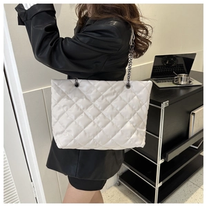 Sac à bandoulière matelassé blanc moderne avec chaîne argentée dans un bureau