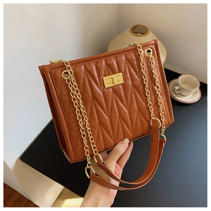 Detail of vintage brown quilted shoulder bag with gold chain strap and turn-lock closure