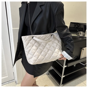 Sac à bandoulière matelassé blanc avec chaîne argentée sur veste en cuir