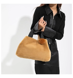 Detailed close-up of soft brown faux fur handbag texture with fabric handle and plush charm