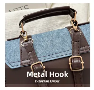 Detail of gold metal hook and denim leather stitching on fashionable shoulder bag
