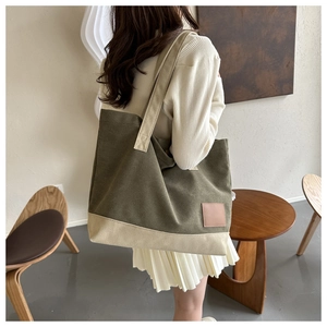 Dettaglio della borsa tote in tela con patchwork verde oliva e beige e toppa in pelle