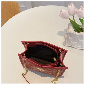 Detail showing red quilted handbag interior with zipper pocket and golden chain strap