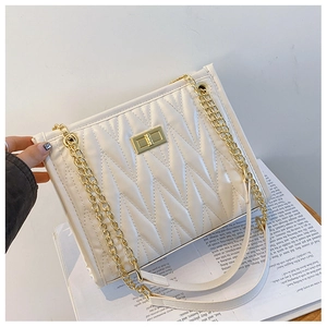 Detail of white pleated shoulder bag with gold chain strap and metallic twist lock closure