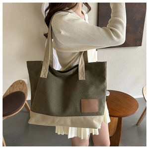 Dettaglio borsa shopper in tela verde militare e beige con toppa in pelle marrone