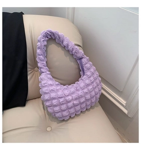 Detail of light purple pleated cloud bag with scrunchie bubble texture on beige sofa