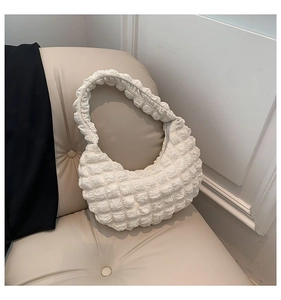 Detailed view of white puckered bubble texture and fabric finish of the crescent hobo bag