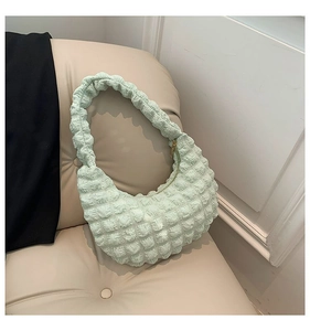 Detailed view of mint green bubble-textured pleated fabric on a stylish hobo shoulder bag