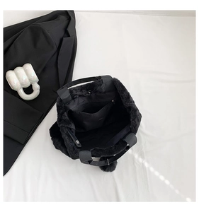Detailed interior of plush black tote bag showing magnetic buckle and lining