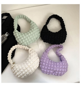 Detailed top view of four cloud-textured bubble handbags in green, black, white, and lilac