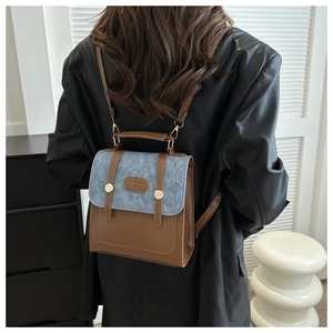 Detail des blau-braunen Leder-Rucksacks mit Denim-Akzenten und goldener Hardware