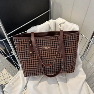 Classic houndstooth tote bag with brown leather straps in a stylish shopping cart setup