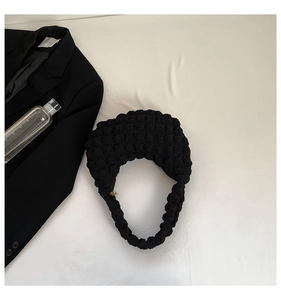 Detail of black bubble cloud pleated fabric texture on chic crescent shoulder bag