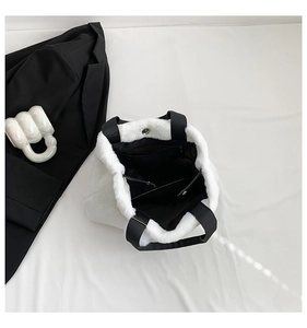 Detail of white faux fur tote bag showing black inner lining and internal zip pocket