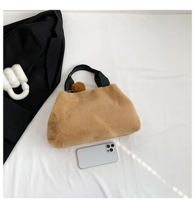 Detailed close-up of khaki plush bucket bag with fuzzy texture and black woven handle