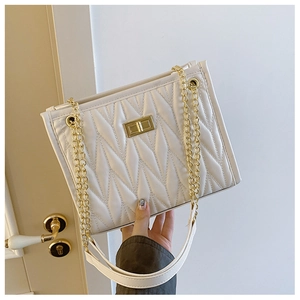 Detail of white pleated shoulder bag with gold metal lock and leather chain strap