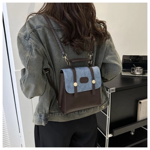 Détail du sac à dos rétro en cuir et denim montrant les bretelles sur le mannequin