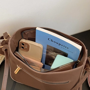 Brown matte crossbody bucket bag with wide strap showing spacious inner compartments