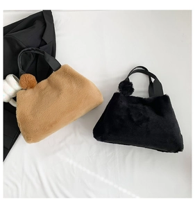 Detail of plush faux fur tote bags in khaki and black with soft pompom charms
