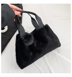 Detail of plush black mini bucket bag with soft faux fur texture and wide ribbon handle