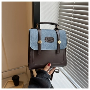 Detail of vintage patchwork handbag with denim blue fabric and brown leather textures