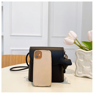 Close-up of small black litchi grain leather crossbody bag with flower size reference