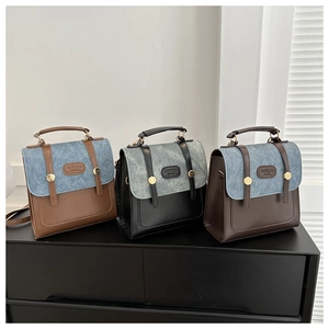 Gros plan des coutures contrastées, rivets dorés et logo embossé sur sacs vintage