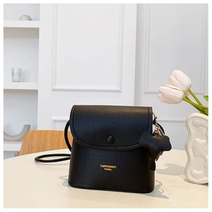 Detail of black lychee grain leather crossbody bag with gold logo and cloud charm