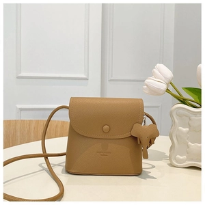 Detail view of khaki pebbled leather crossbody bag with cute elephant charm and flap closure