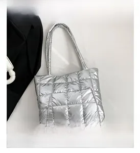 Détail du sac cabas matelassé argenté avec finition métallique sur fond minimaliste