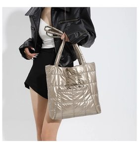 Détail du sac cabas matelassé doré champagne avec texture métallique et poche frontale