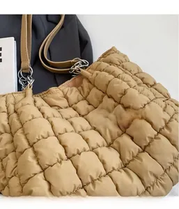 Macro detail of beige quilted square pattern fabric on casual large tote bag