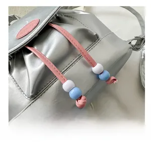 Dettaglio ravvicinato di mini zaino argento con perline e logo fashion in rilievo