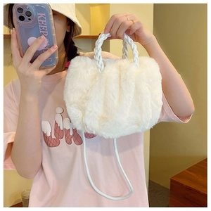 Detail of white plush handbag featuring woven handle and soft faux fur texture
