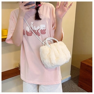 Close-up of white plush crossbody bag featuring fluffy faux fur and woven top handles