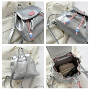 Détail du mini sac à dos argenté montrant la capacité intérieure pour portefeuille et lunettes