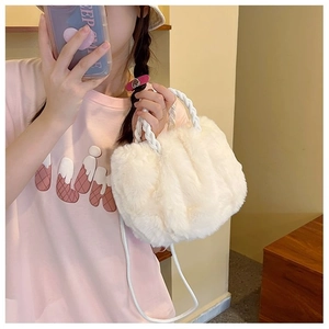 Detail of soft white plush handbag with woven handles and versatile shoulder strap