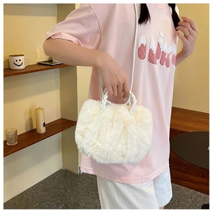 Detail of white fluffy faux fur handbag featuring elegant white braided rope handles