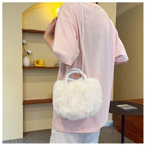 Detail of white plush handbag featuring woven texture handle and detachable shoulder strap